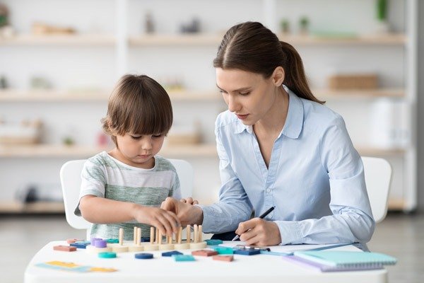 Pediatric Homecare for Autism Children in Lilburn, Georgia. A nurse having therapy with autism child at home.